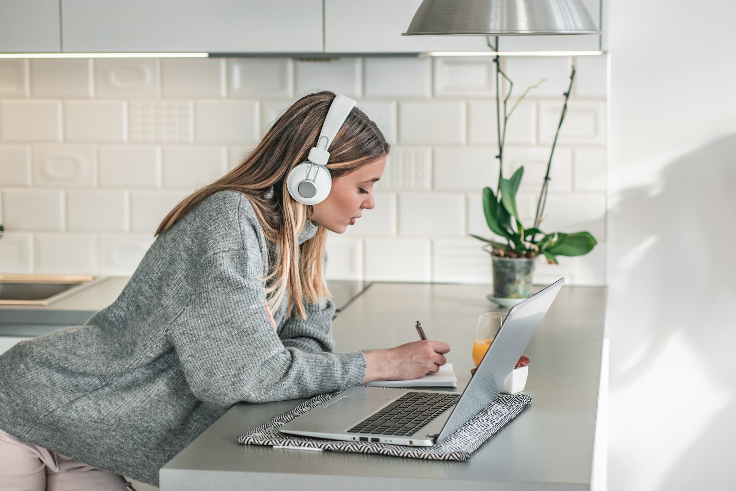 A young woman listening to online course indoors